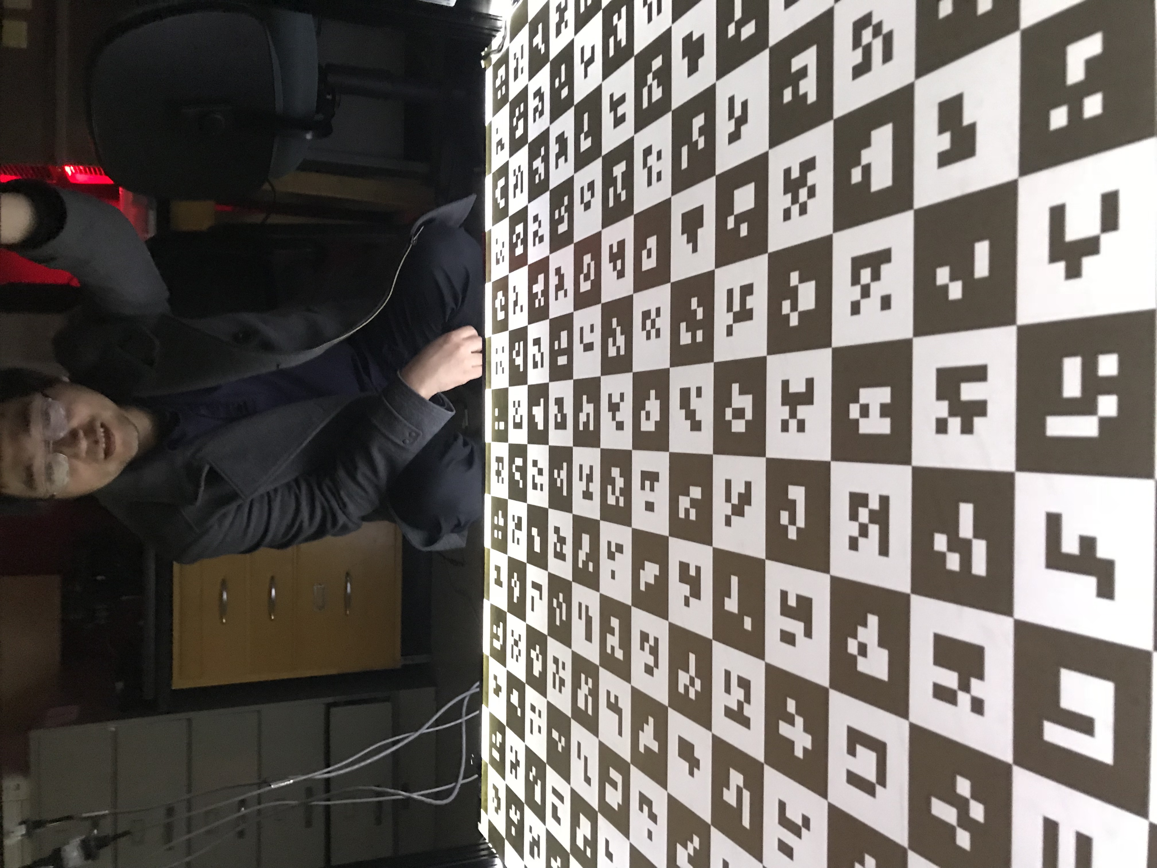 Former PhD student Ying Yu looking at a back-lit caltag calibration pattern used for structured light scanner calibration