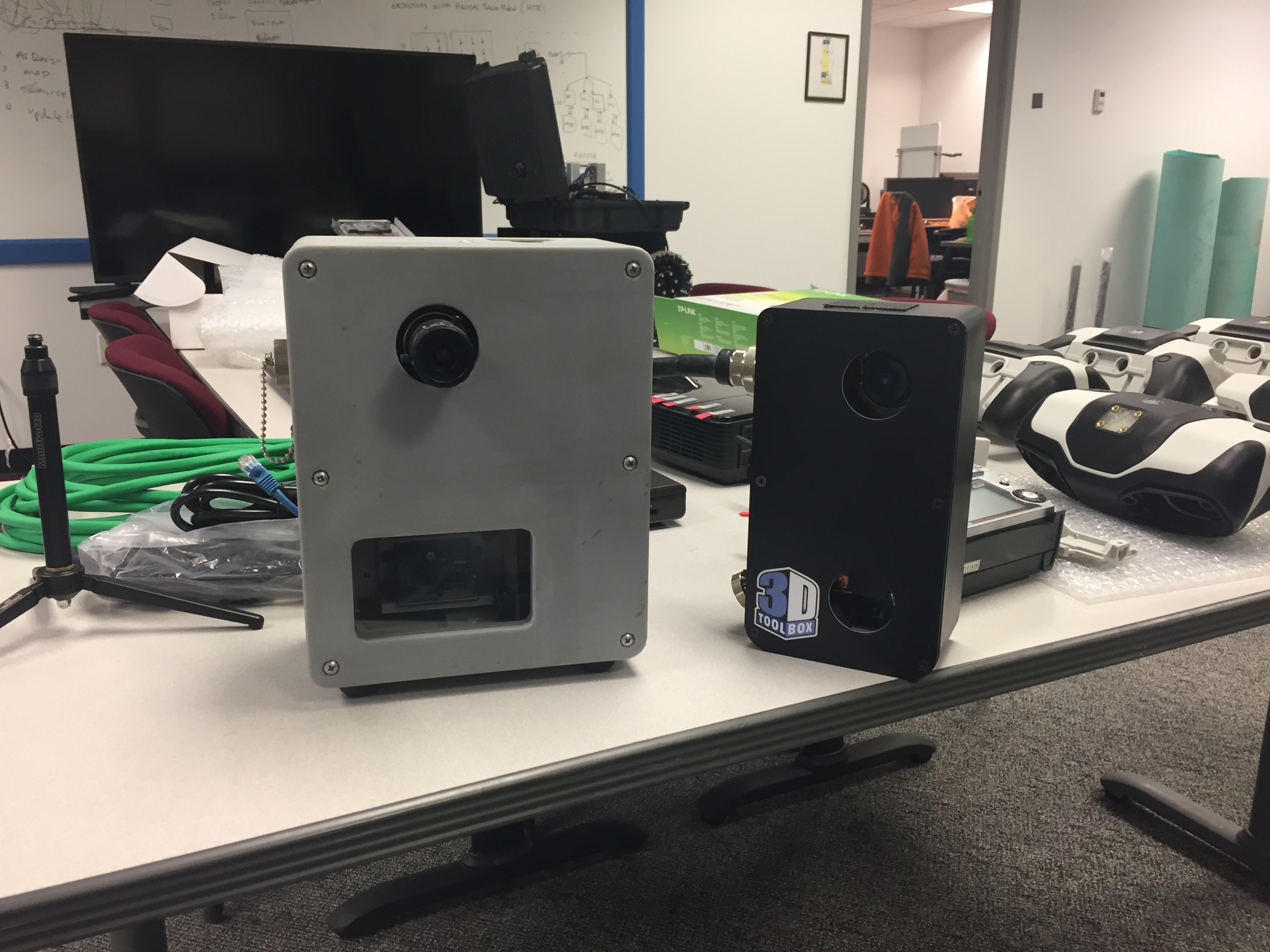 Two early Seikowave scanners: the system on the right survives a 1-meter drop onto concrete without recalibration; the system on the left is inside a 3D-printed enclosure for machine-mounted use